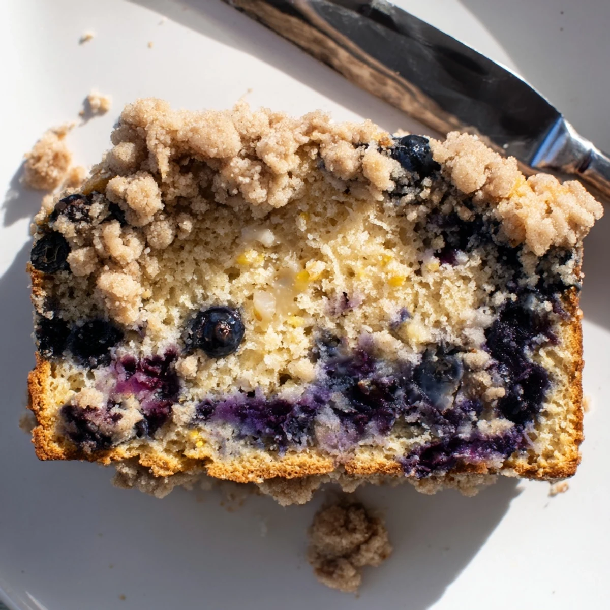 Freshly baked Lemon Blueberry Bread with Cinnamon Streusel Topping cooling on a wire rack, featuring a golden crust and sugary crumbs. 