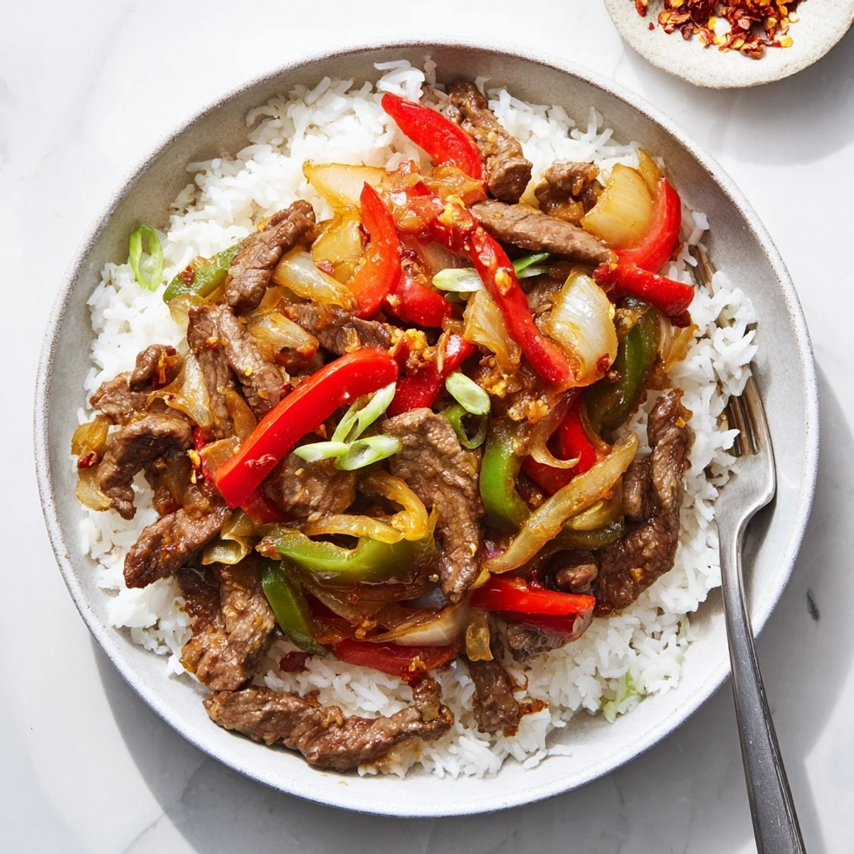 This hearty Spicy Beef Stir-Fry with Rice showcases caramelized beef strips, aromatic ginger, and chili paste over a bed of steamed rice.