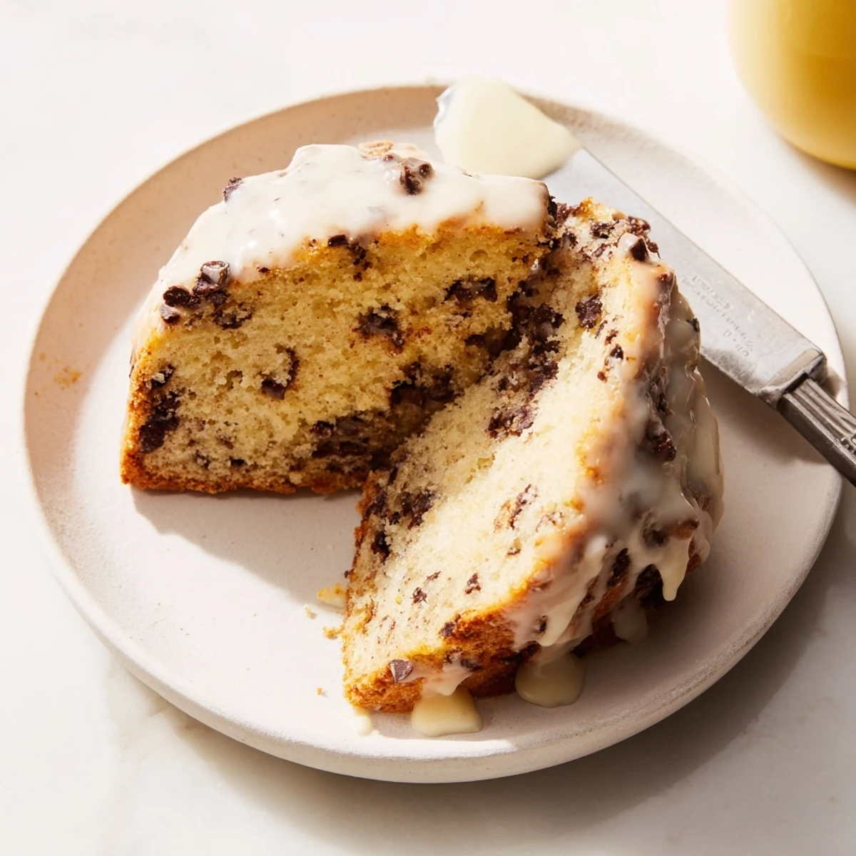 A close-up of warm Chocolate Chip Scones with Glaze, highlighting the shiny vanilla drizzle over tender, buttery wedges.  