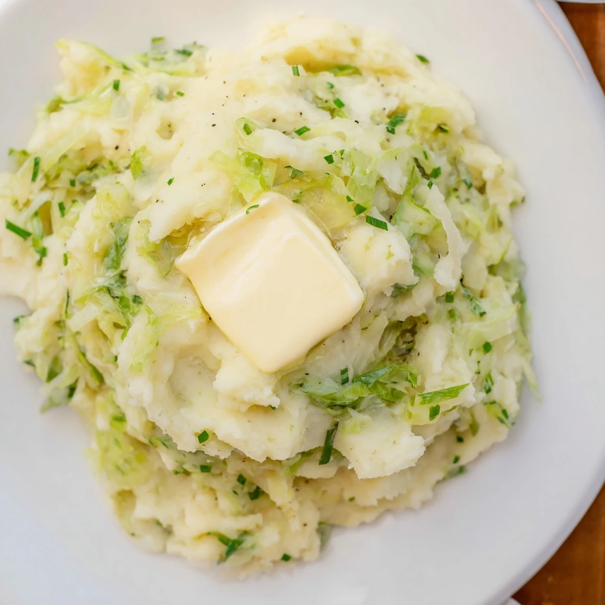 Hearty Irish Cabbage and Potato Mash served as a cozy side, speckled with scallions and butter.