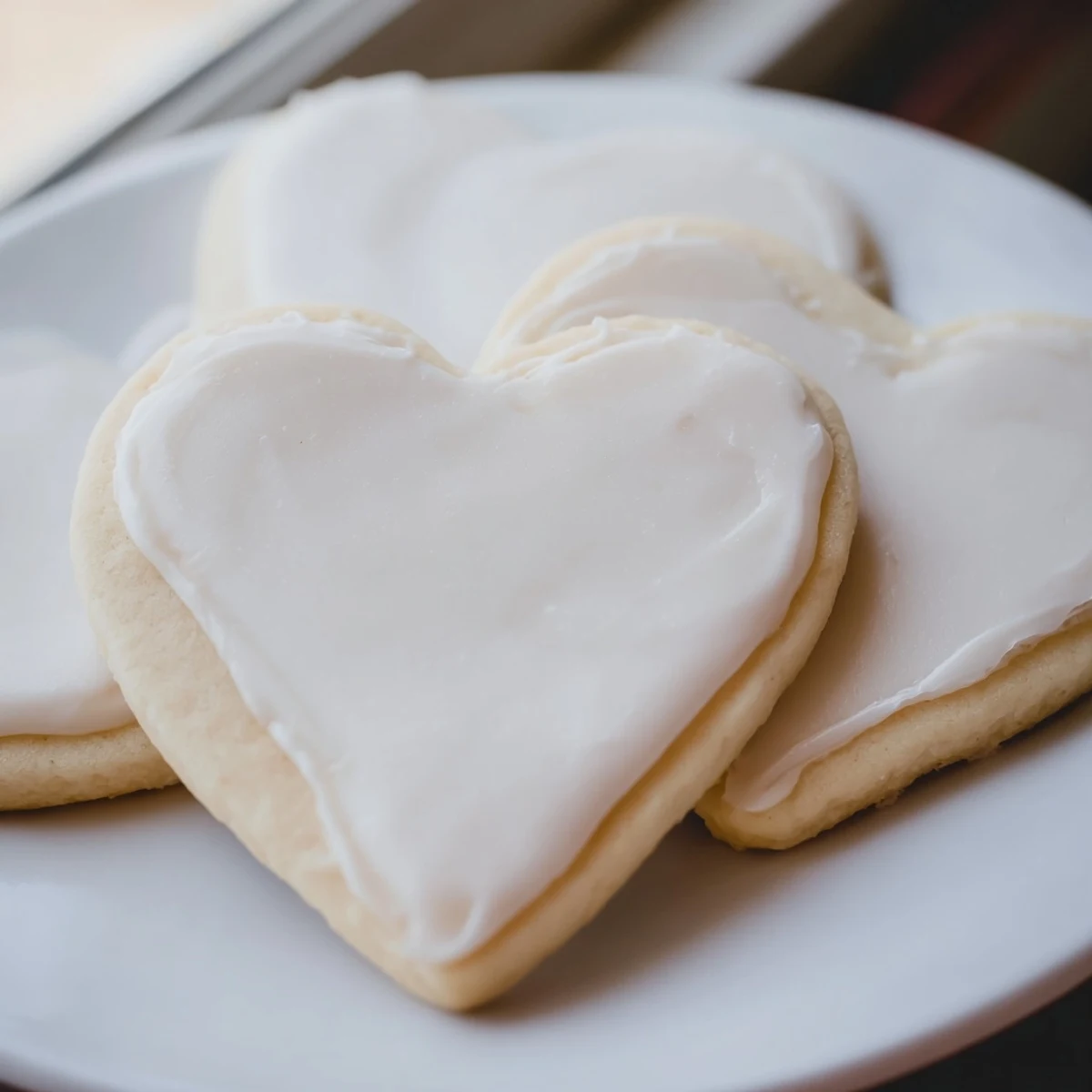Close-up of Heart Shaped Sugar Cookies decorated with red and pink royal icing swirls.