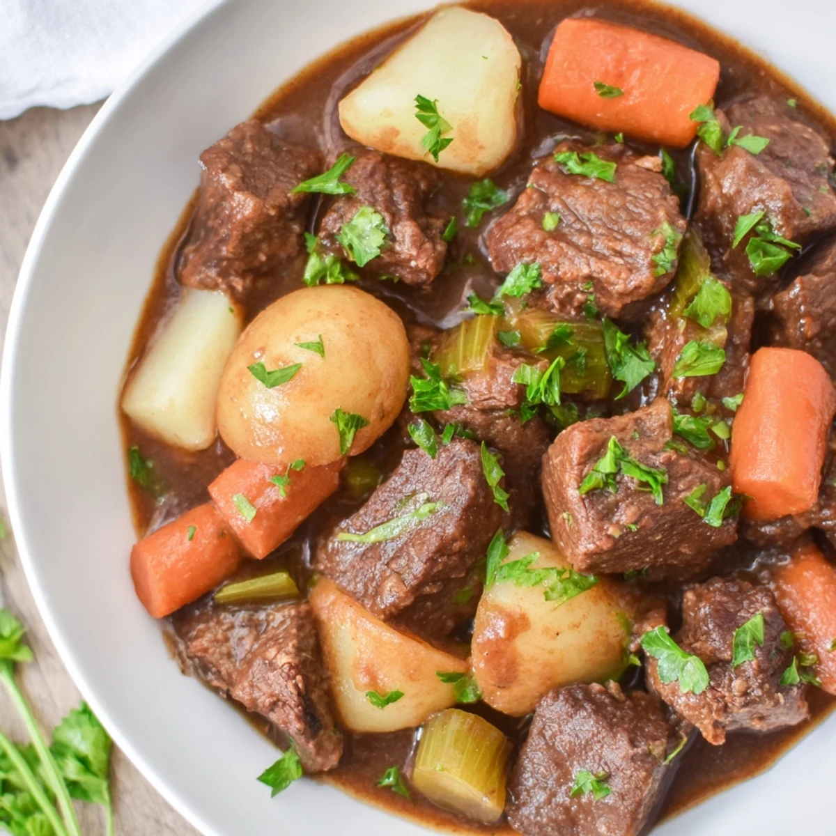 Steaming bowl of Irish Beef Stew with Guinness-Style Alcohol-Free Sauce, packed with tender beef chunks and colorful root vegetables like carrots and potatoes.  