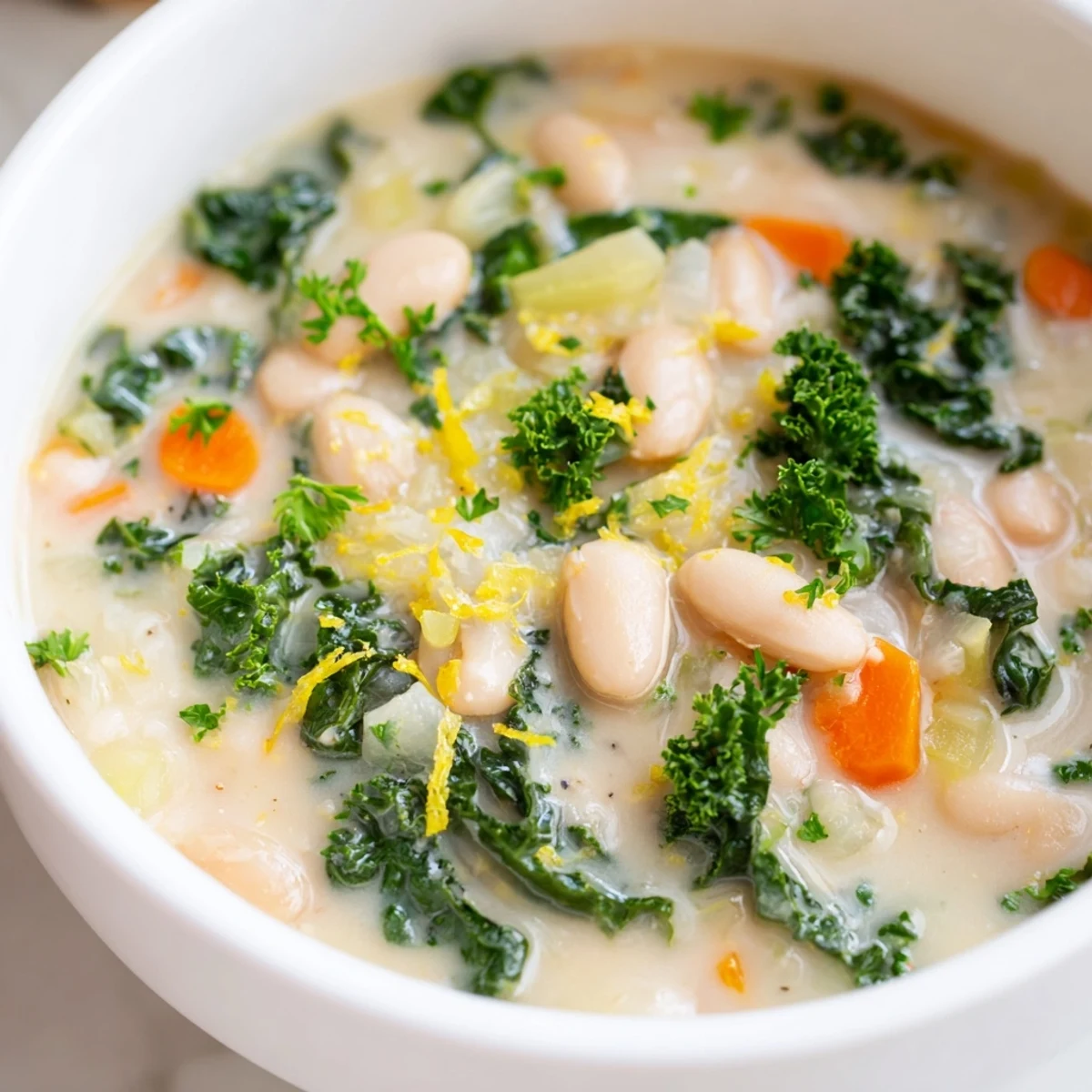 Creamy white beans and tender kale swim in a fragrant broth of White Bean and Kale Soup with Lemon Zest.