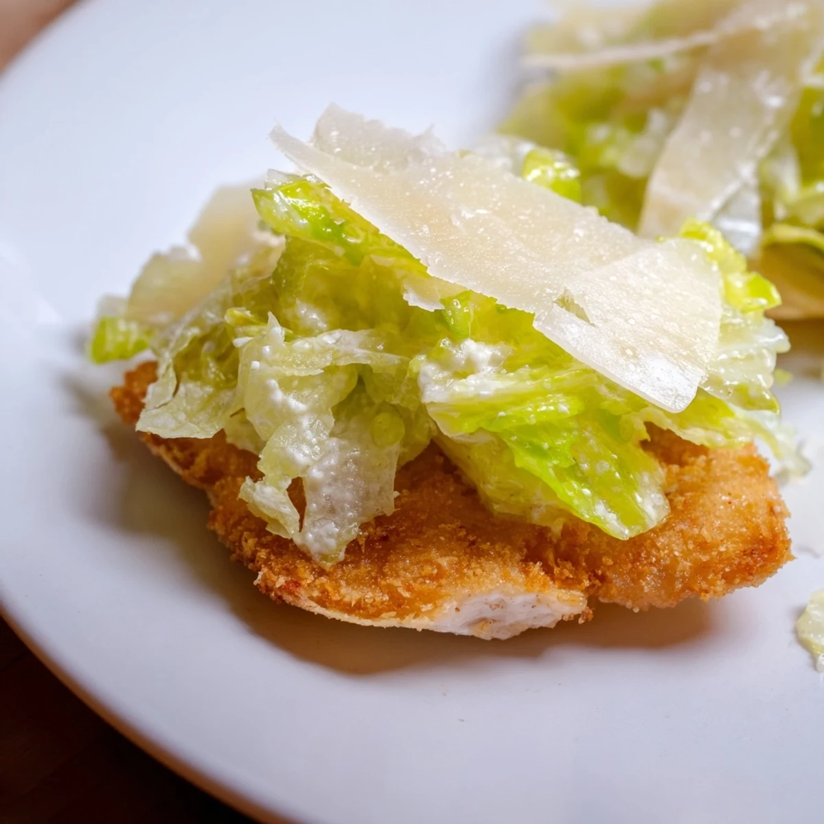 Golden baked potato chips topped with Crispy Chicken Caesar Salad Chips, featuring crunchy chicken pieces and fresh romaine lettuce for a bite-sized appetizer.