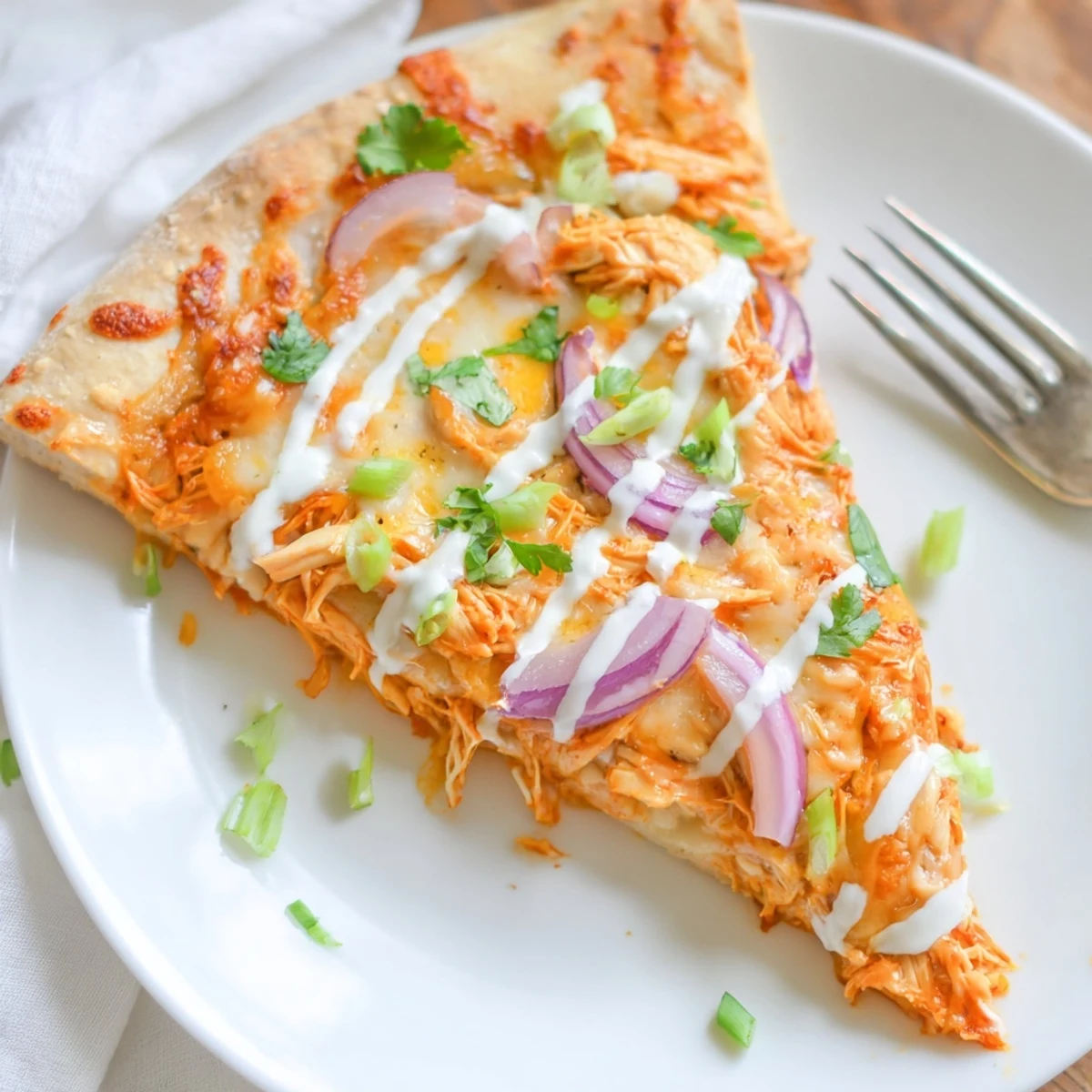 Sizzling Bold Buffalo Chicken Pizza slice showcasing shredded buffalo chicken, onions, and melted cheese on crust.