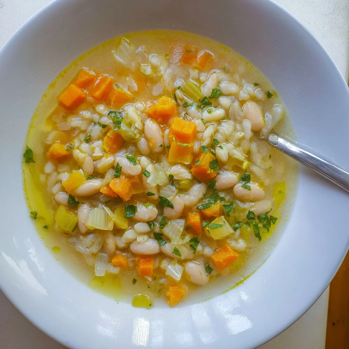 Hearty white bean soup featuring rosemary and garlic simmered to perfection with diced vegetables