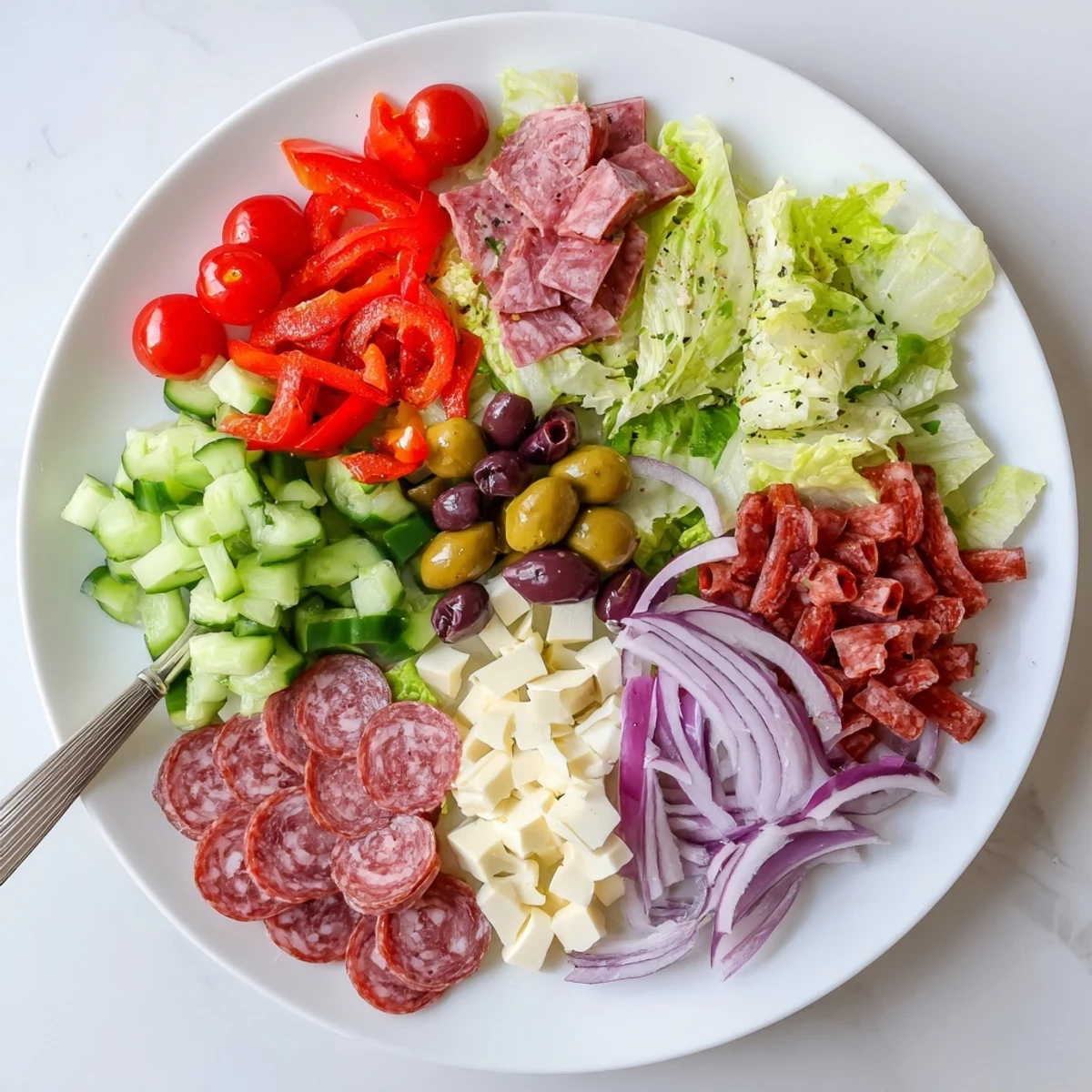Vibrant Italian chopped salad bowl with fresh vegetables, salami, and homemade dressing