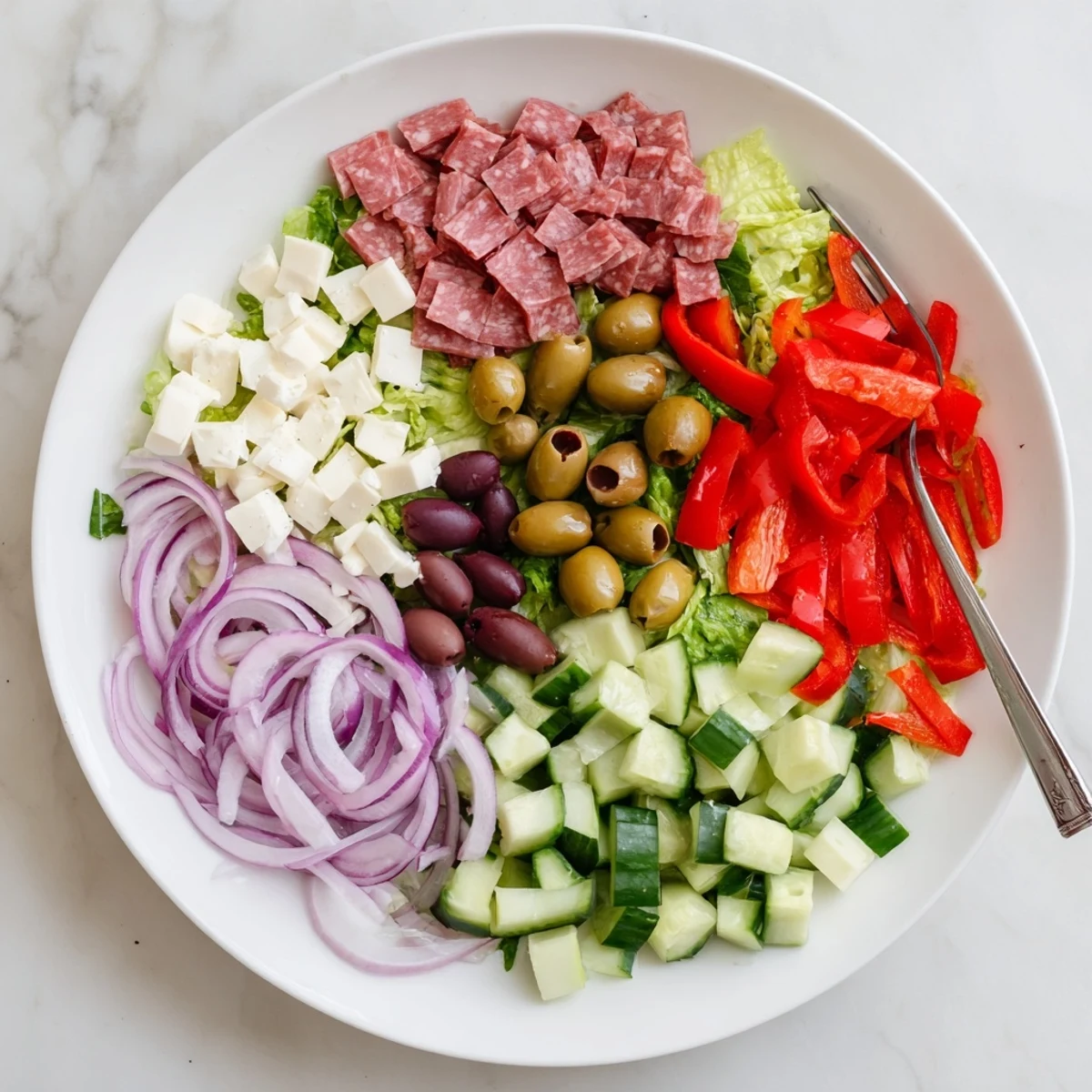 Mediterranean-style chopped salad featuring crisp lettuce, tomatoes, olives, and tangy Italian vinaigrette