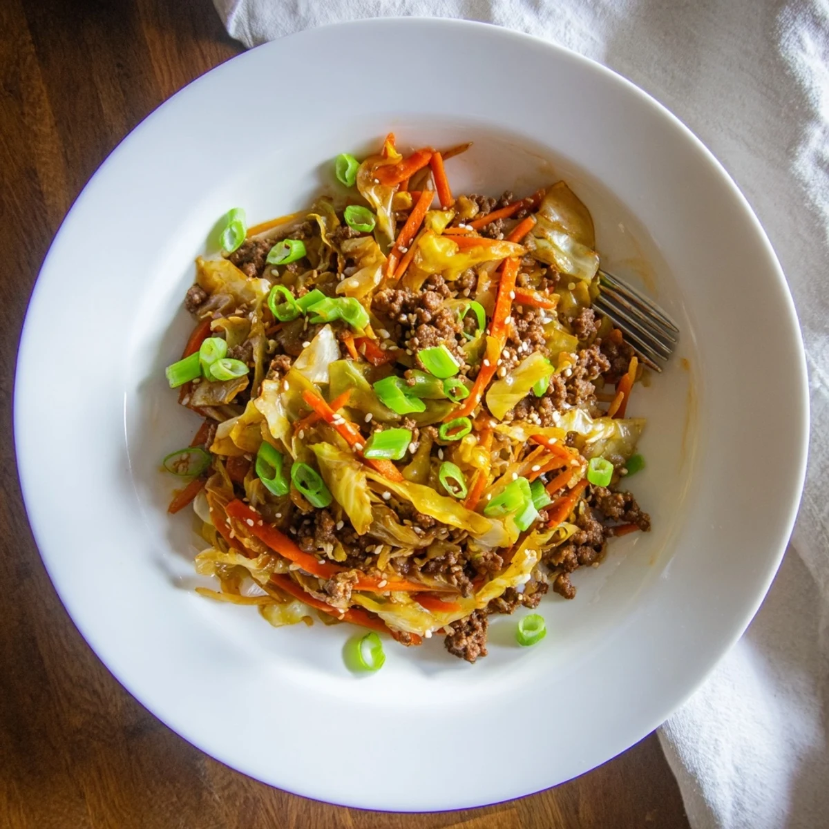 Hearty ground beef and cabbage stir fry served steaming hot with tender crisp vegetables and aromatic seasonings