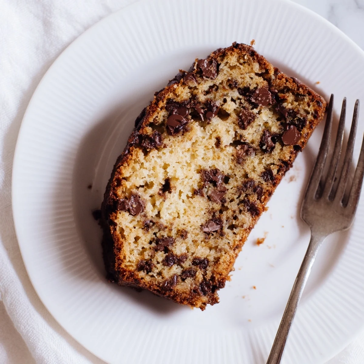Sliced moist chocolate chip banana bread showing soft texture and scattered chocolate chunks