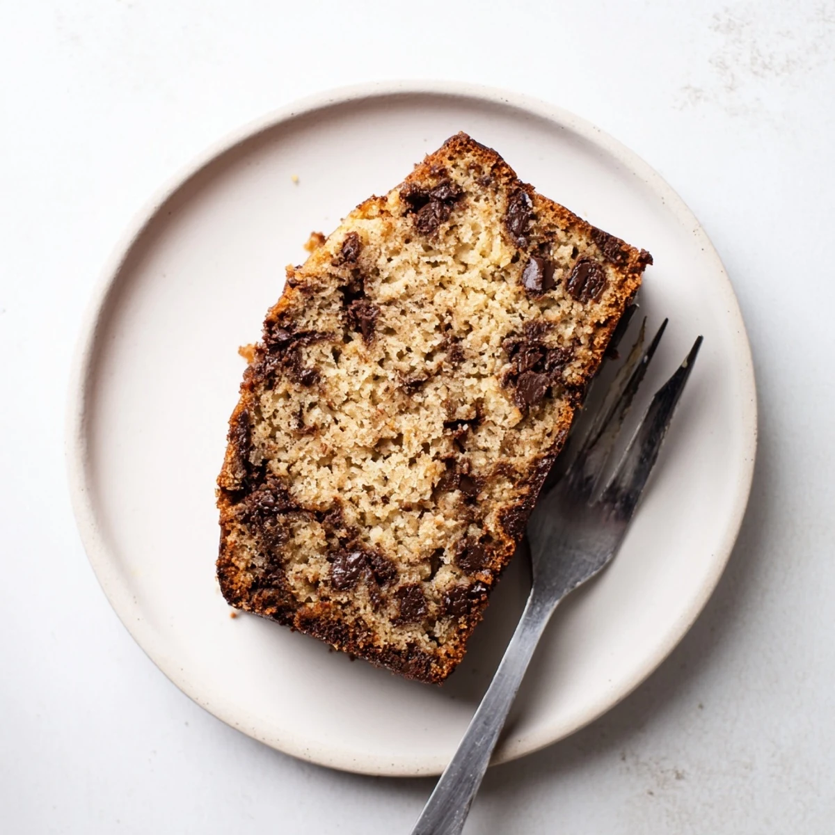 Freshly baked chocolate chip banana bread in loaf pan with golden crust