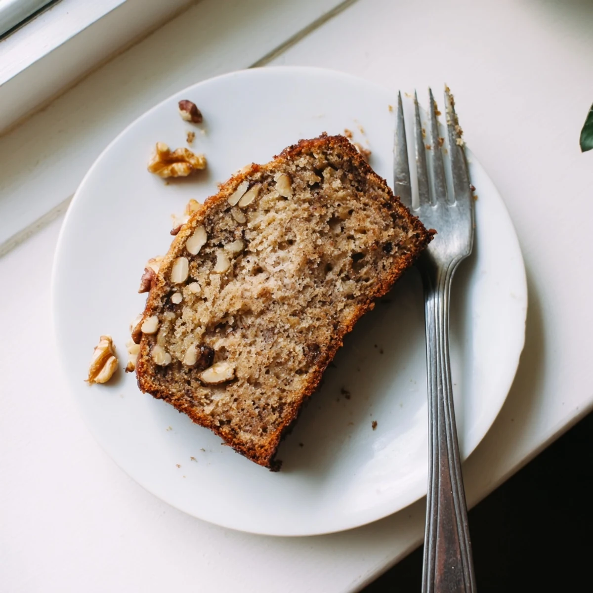 Golden brown best ever banana bread loaf with a cracked top, sliced to reveal moist tender interior