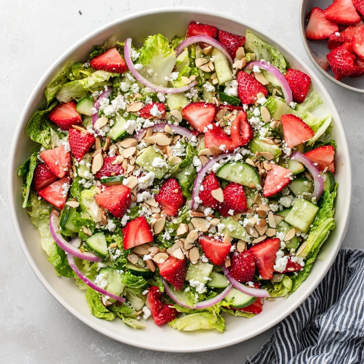 Fresh crunchy strawberry romaine feta salad with vibrant red berries, crisp lettuce, and tangy white feta crumbles