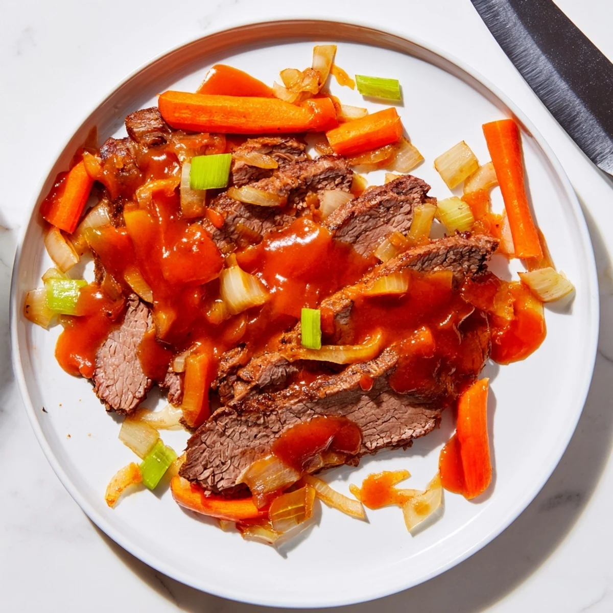 Tender slow cooker beef brisket slices plated with roasted carrots and rich glossy gravy