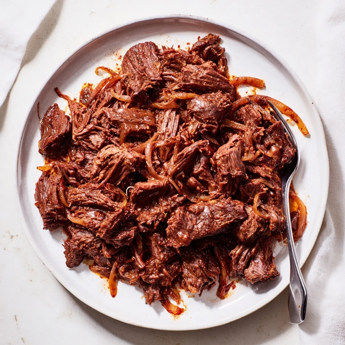 Savory Crock Pot shredded beef with aromatic spices, ideal for rice bowls or burritos