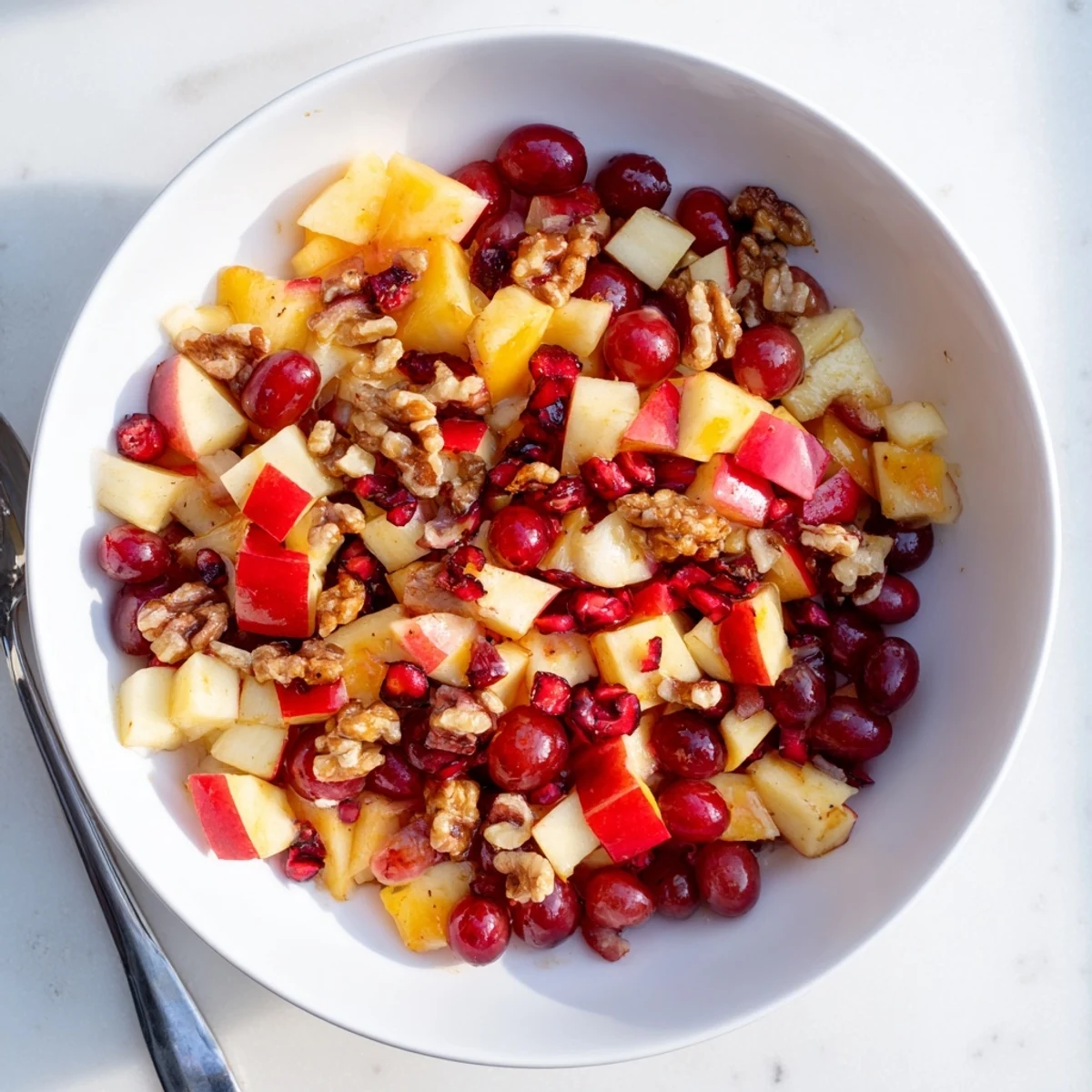 Colorful bowl of fresh Minute Fall Fruit Salad tossed with citrus-honey dressing and crunchy walnuts