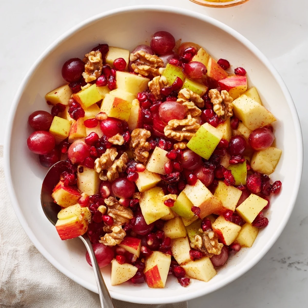 Rustic wooden board displaying layered Minute Fall Fruit Salad with diced apples, pears, and vibrant pomegranate arils