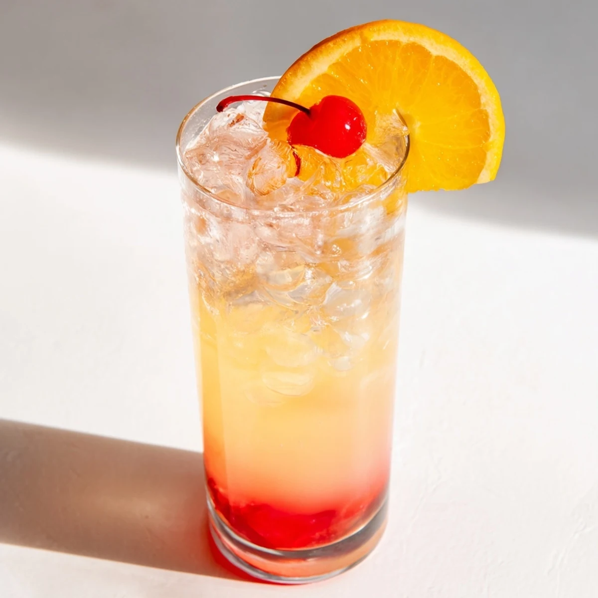 Refreshing Easy Shirley Temple Drink with grenadine swirls and bright maraschino cherry garnish in tall glass