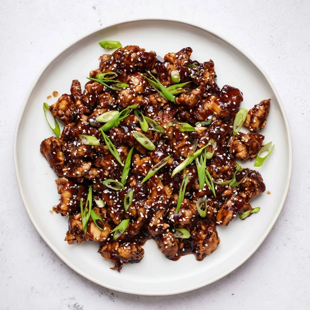 Golden brown Crockpot Teriyaki Chicken coated in sticky homemade teriyaki glaze with sliced scallions
