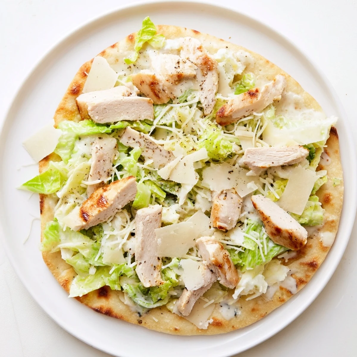 Golden chicken Caesar flatbread with melted mozzarella and crisp romaine lettuce