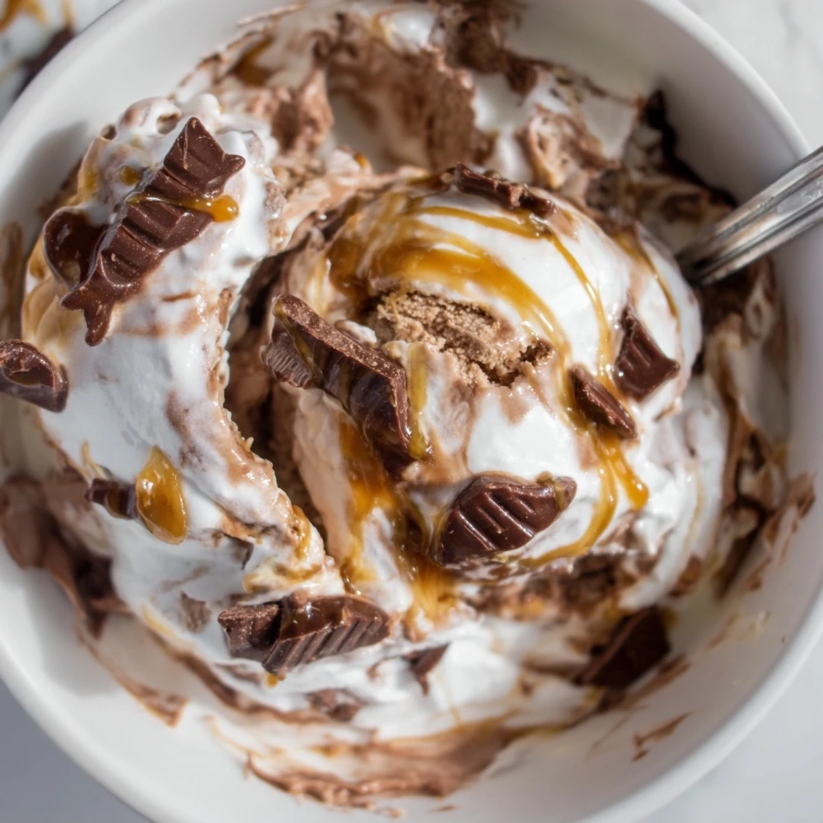 Chocolate Ninja Creami Phish Food ice cream topped with mini chocolate fish and caramel sauce.