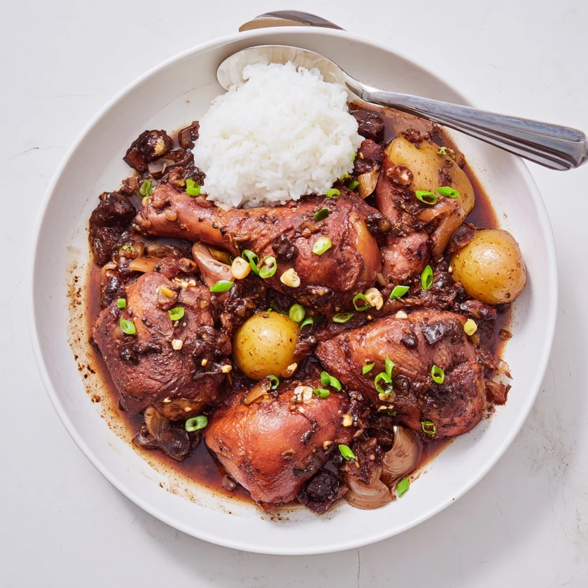 Tender chicken thighs braised in savory soy vinegar garlic sauce with steamed jasmine rice