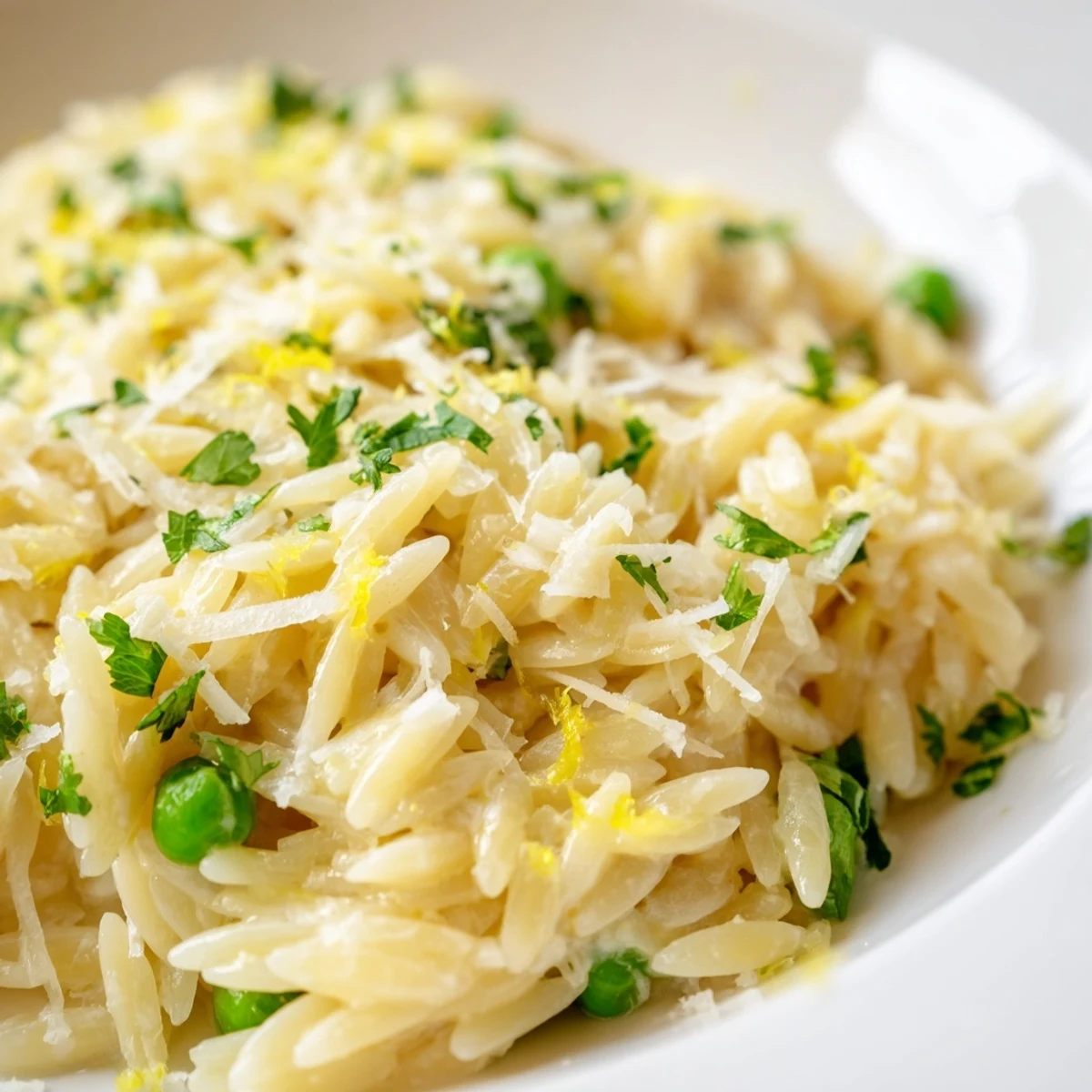 Creamy lemon orzo pasta with fresh parsley and grated Parmesan cheese in a bowl