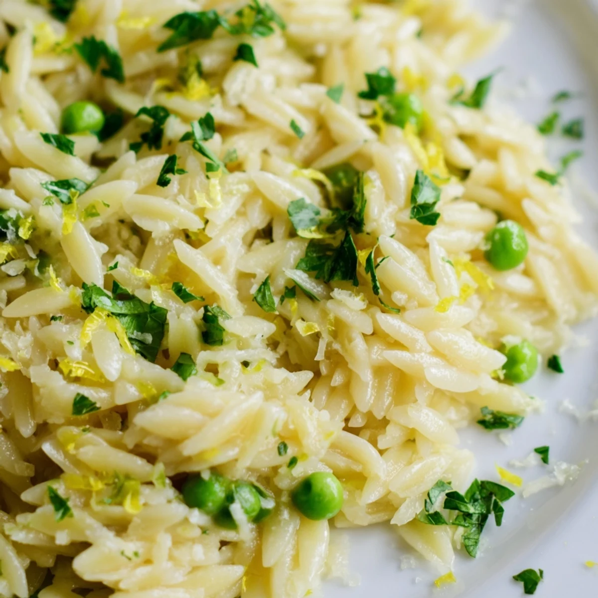 Golden lemon orzo side dish topped with Parmesan and vibrant fresh parsley garnish