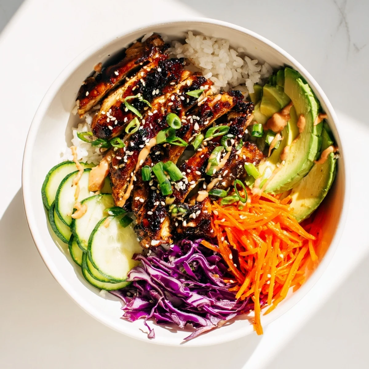 Golden glazed Korean BBQ chicken sliced over steaming white rice with colorful shredded vegetables and creamy gochujang drizzle