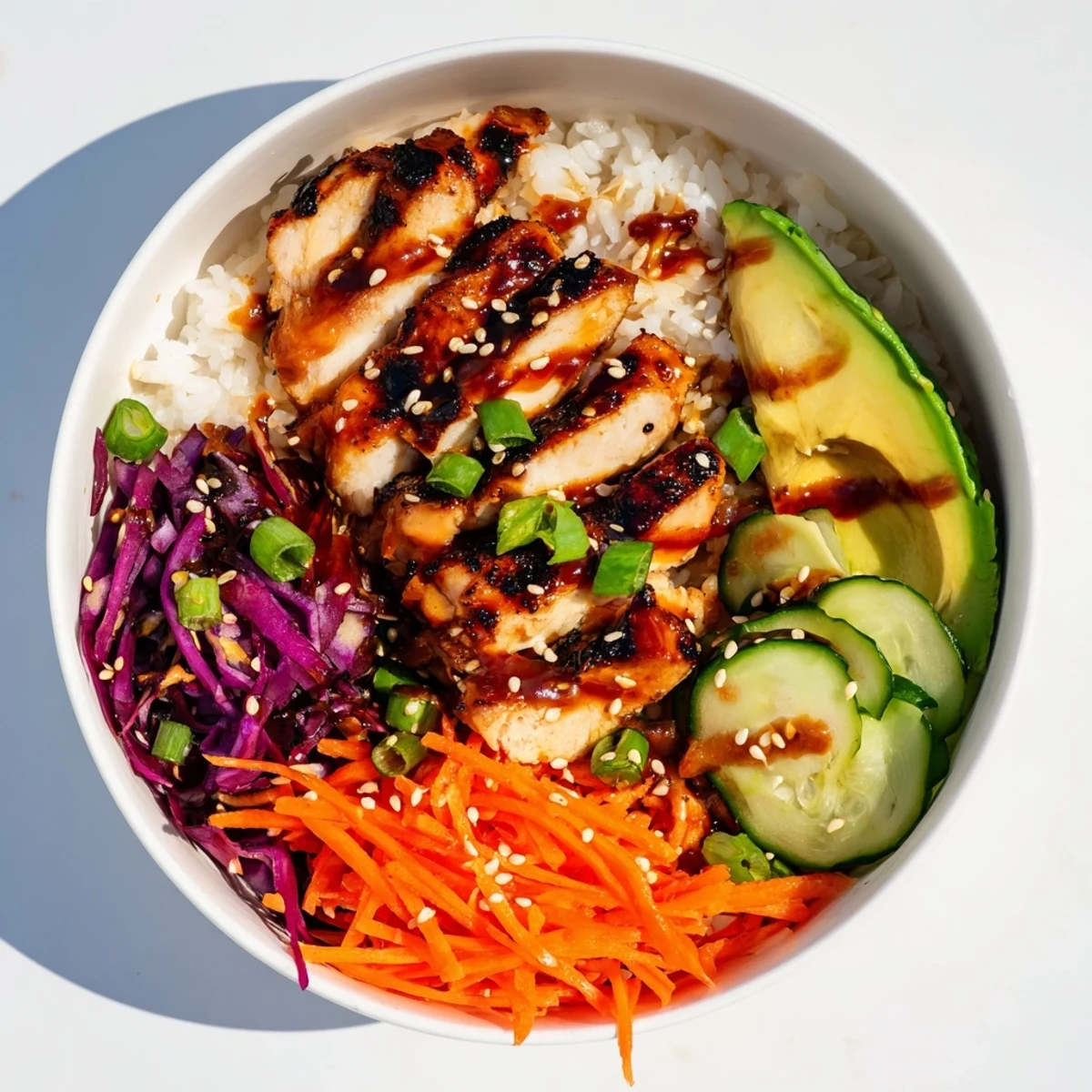 Sizzling grilled Korean BBQ chicken pieces arranged in a bowl with fresh purple cabbage and spicy mayo topping