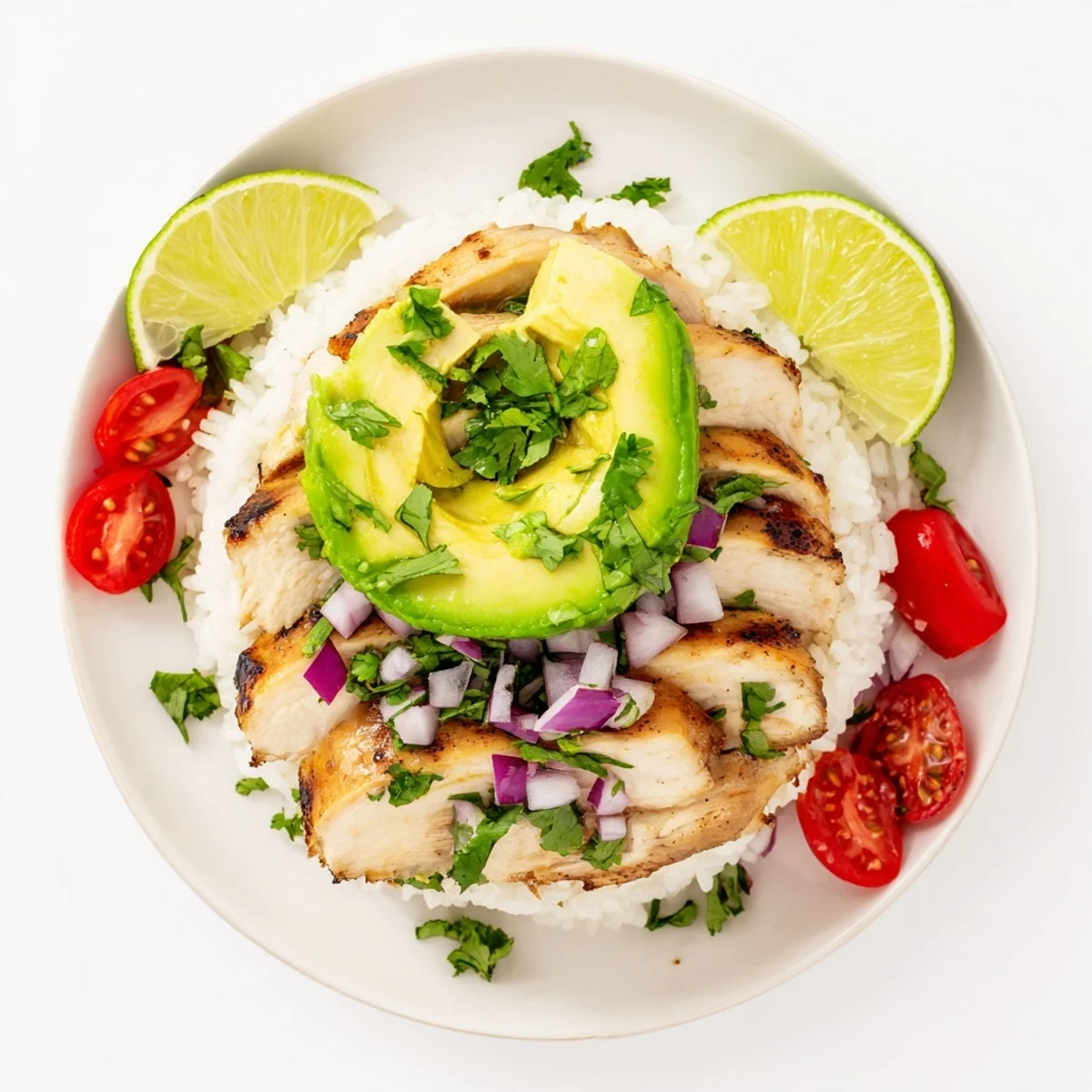 Golden grilled honey lime chicken breast slices arranged over a rice stack with ripe avocado and lime wedges