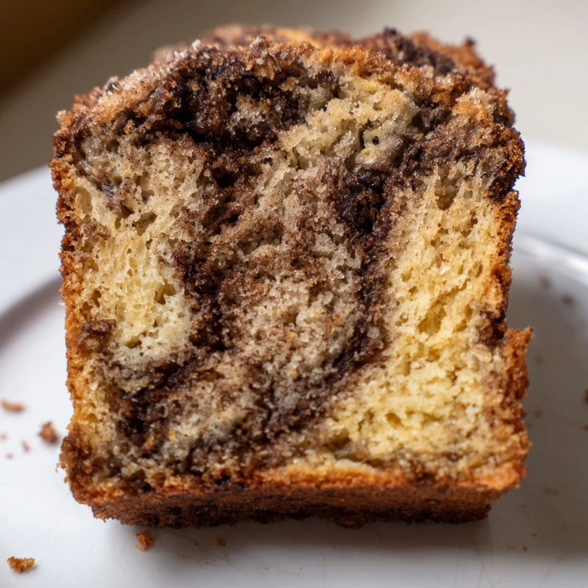 Moist cinnamon sugar swirl banana bread loaf with caramelized streusel topping cooling on wire rack