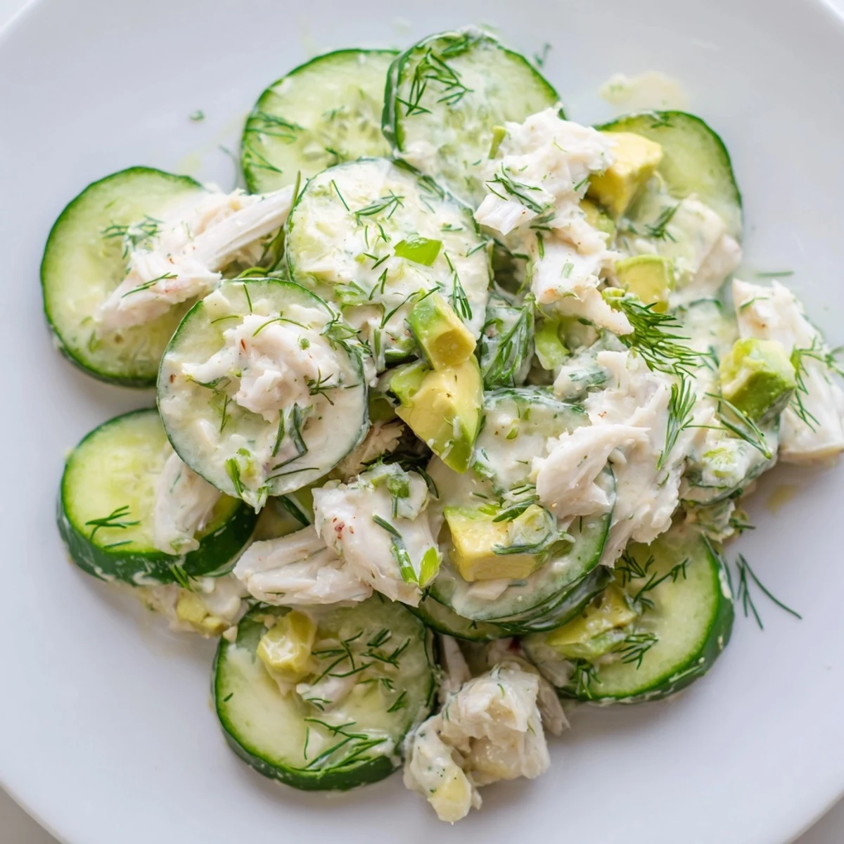 Crisp cucumber salad with crab meat tossed in creamy dressing, garnished with fresh dill