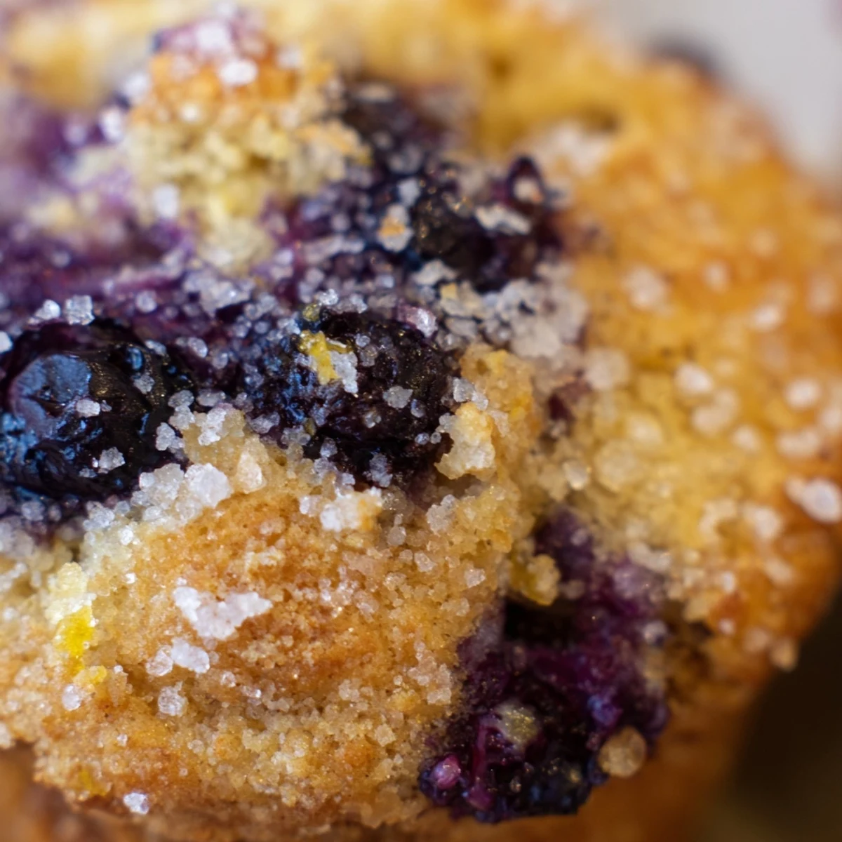 Golden lemon blueberry muffins with burst berries and sparkling sugar topping