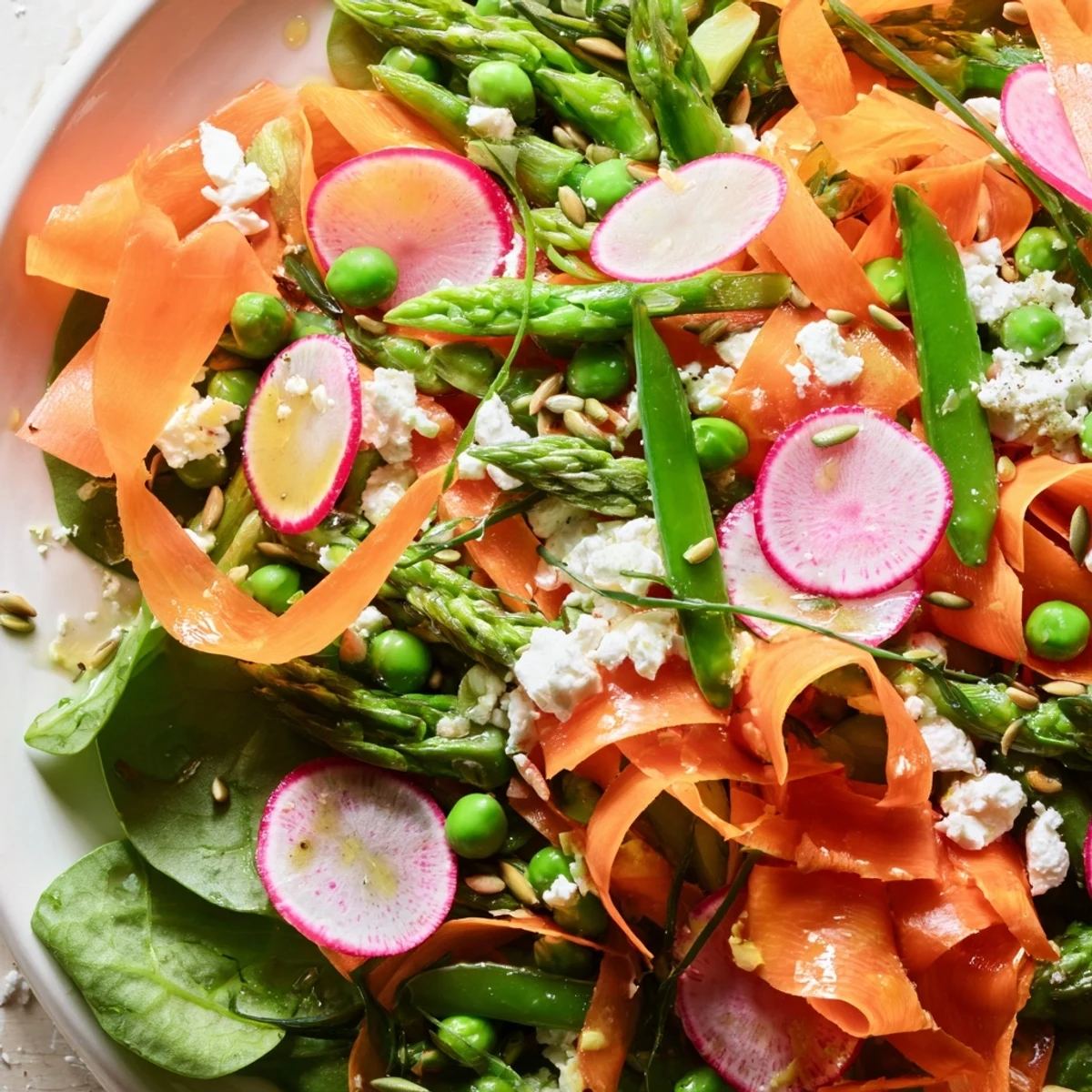 Vibrant Bright Spring Salad with shaved carrot ribbons radishes and a citrusy vinaigrette
