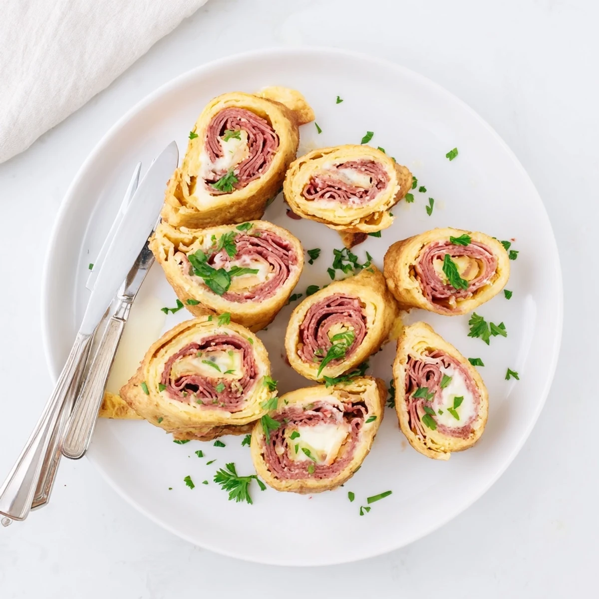 Golden Low Carb Reuben Egg Roll Ups stuffed with corned beef and melted Swiss cheese