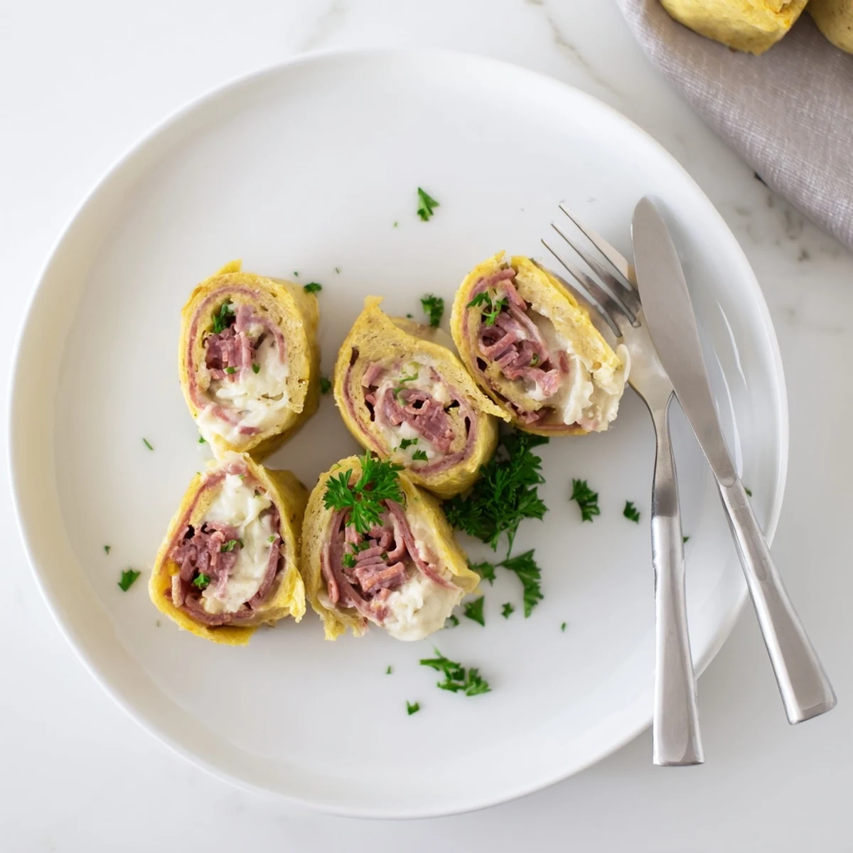 Tender egg wraps filled with tangy sauerkraut and savory Low Carb Reuben Egg Roll Ups