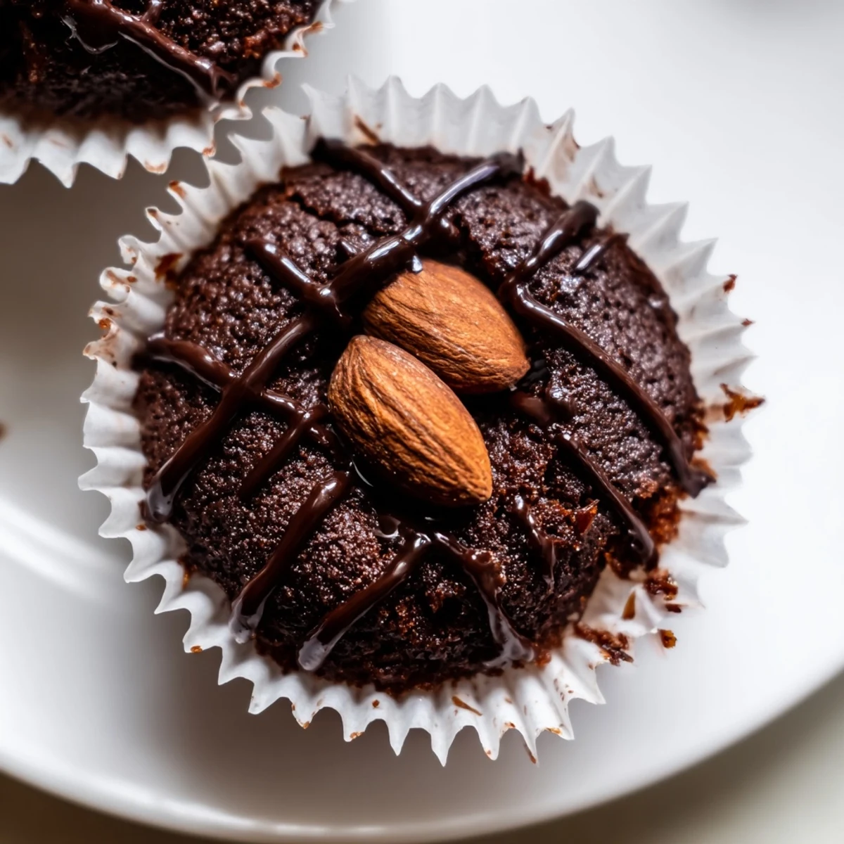 Decadent flourless almond joy cupcakes with gooey coconut centers drizzled in dark chocolate