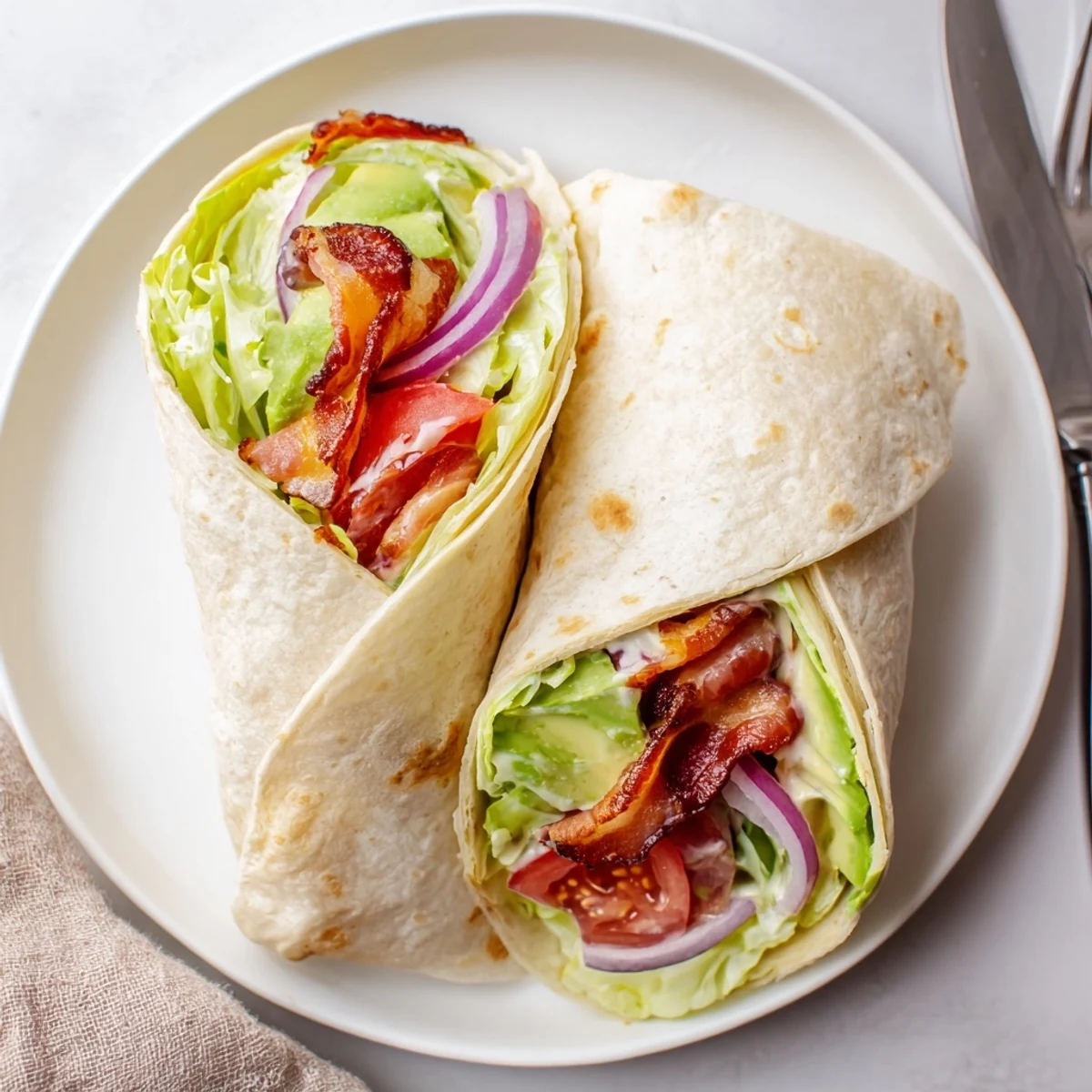 Meal Prep BLT Wraps sliced to show crispy bacon, juicy tomatoes, creamy dressing.