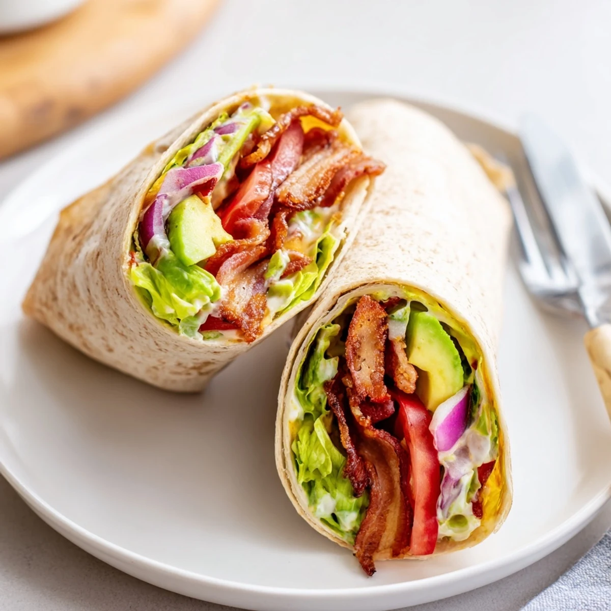 Stacked Meal Prep BLT Wraps wrapped in foil, ready for weekday lunches.