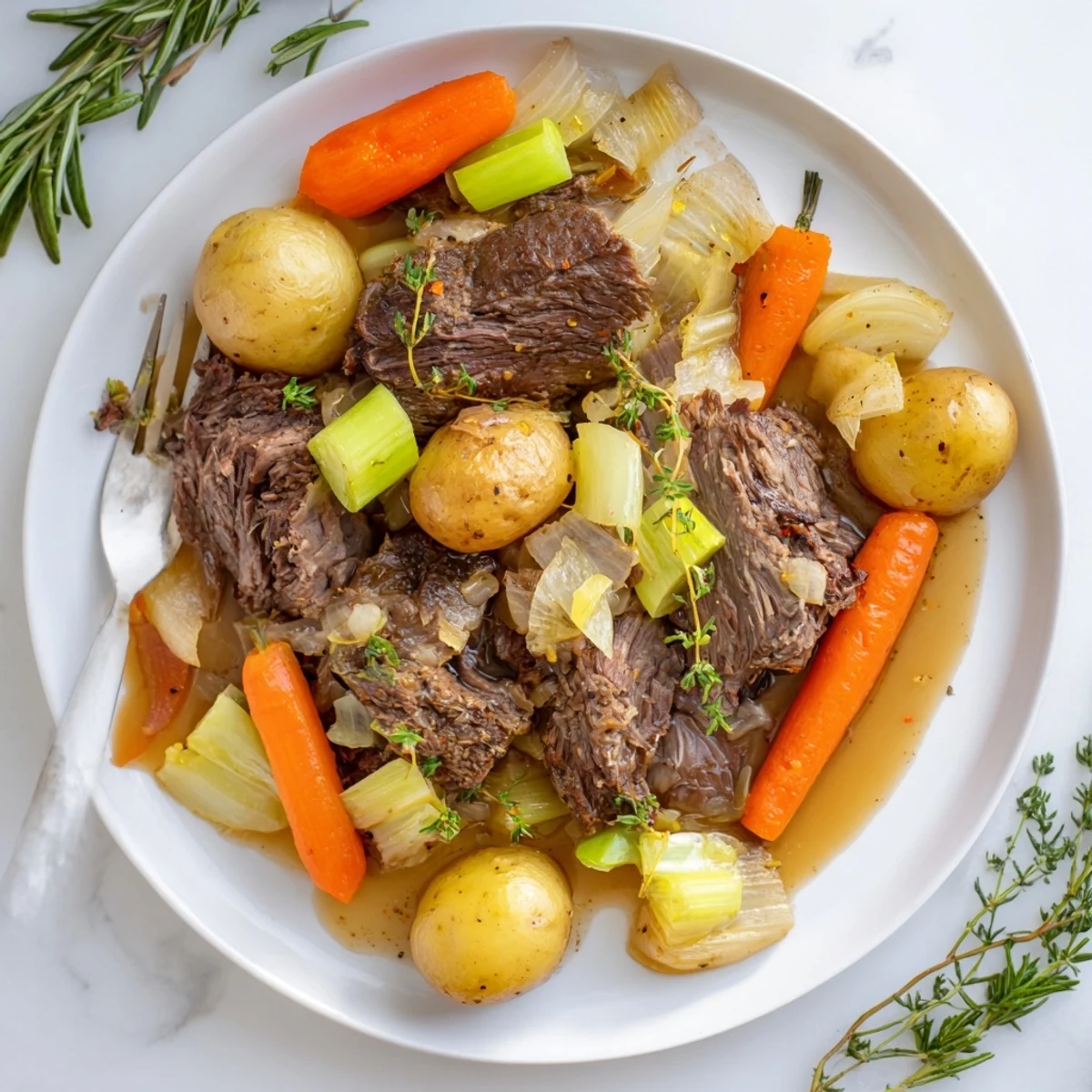 Comforting herb braised beef chuck roast plated with baby potatoes in red wine sauce