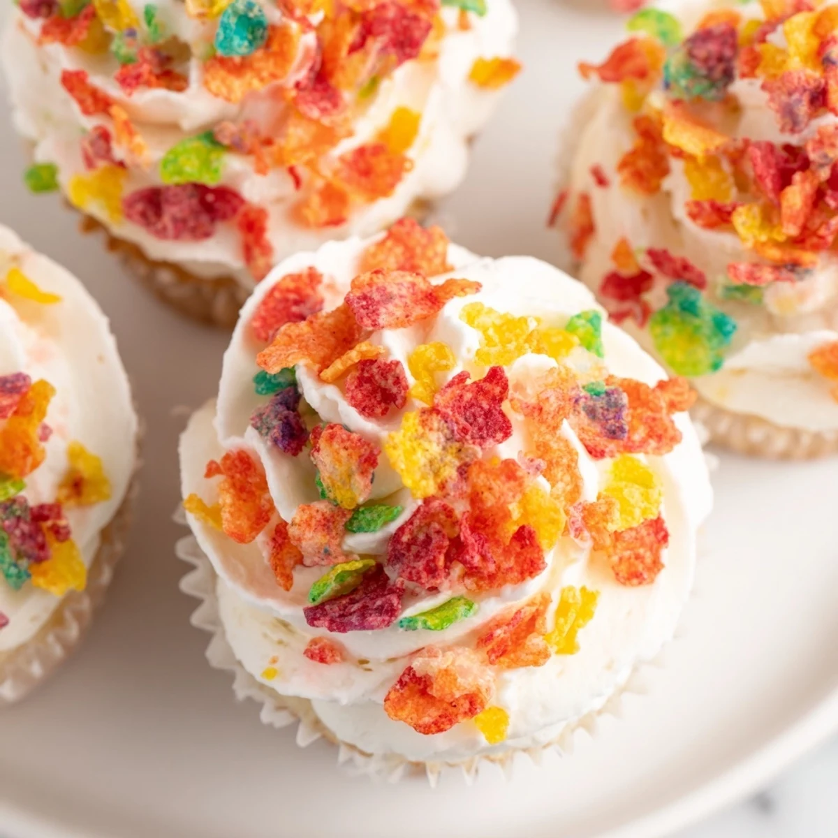 Smooth buttercream frosting studded with crunchy Fruity Pebbles cereal, perfect for dessert topping