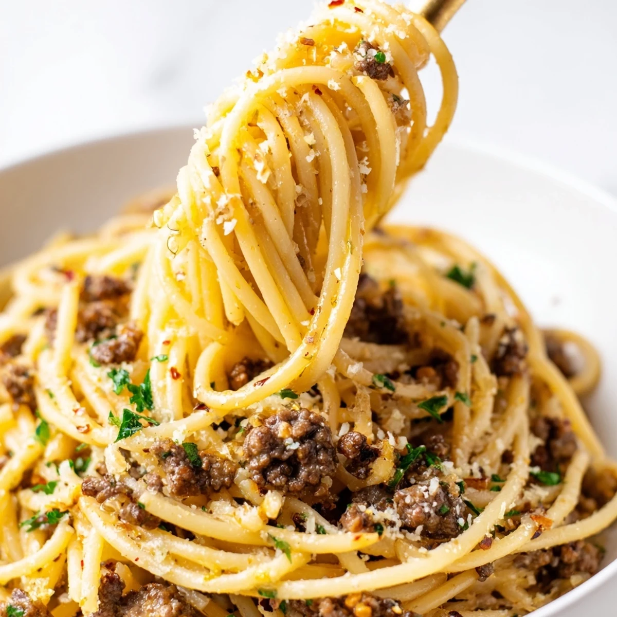 Garlic butter pasta with ground beef topped with fresh parsley and Parmesan cheese