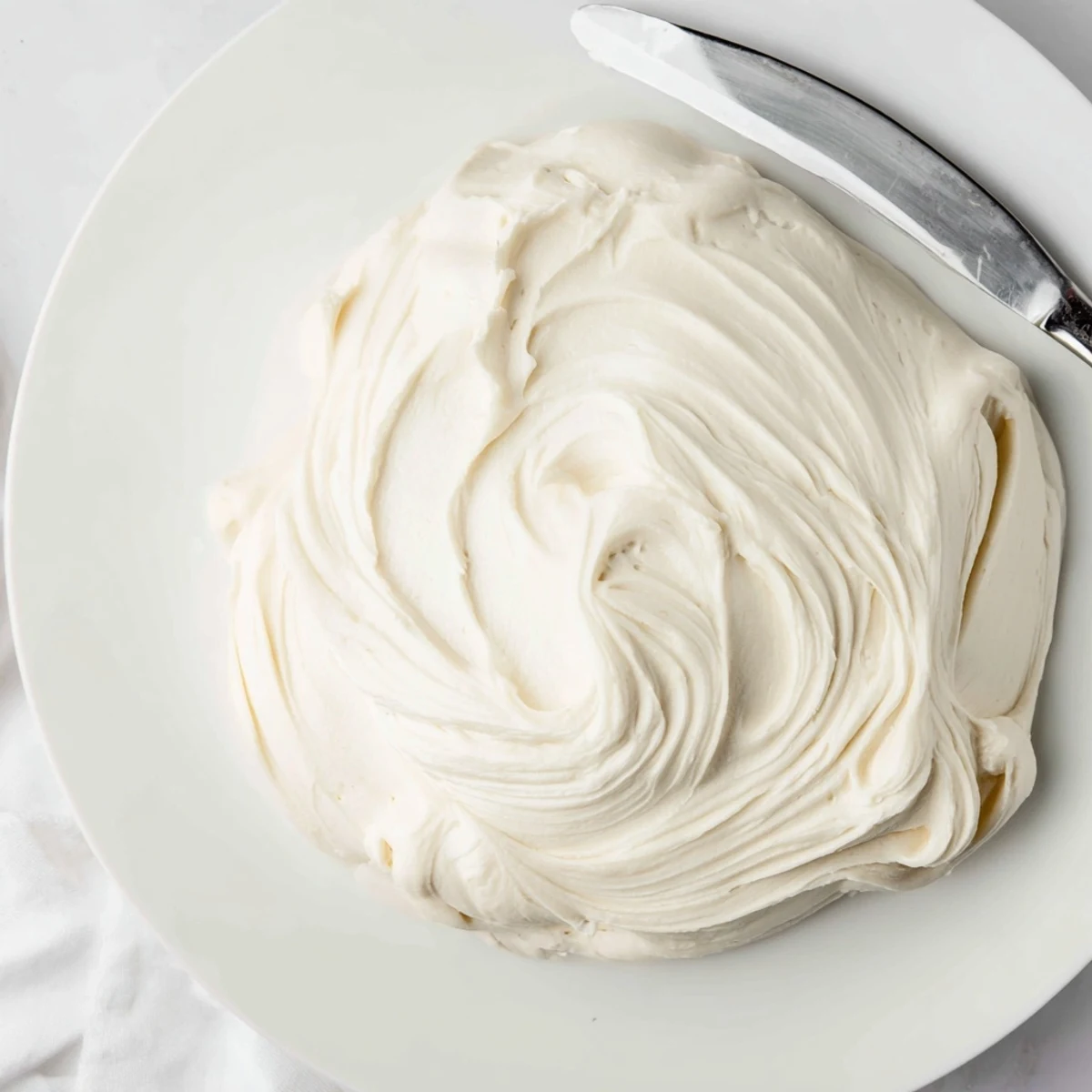 Creamy Italian Meringue Buttercream swirled atop a golden layer cake