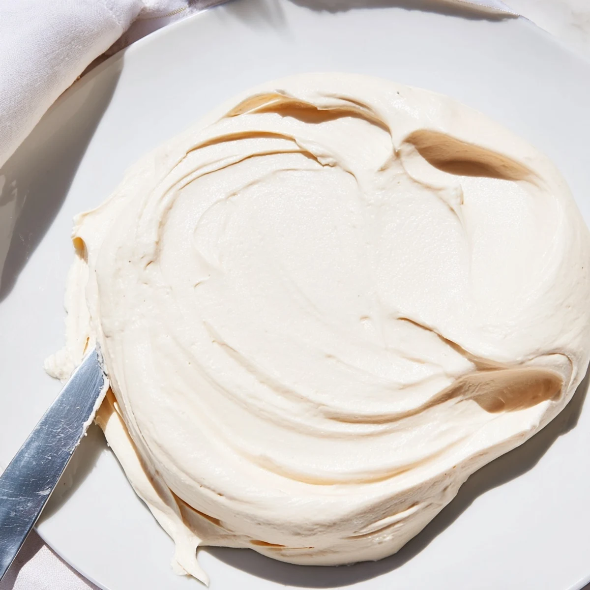 Glossy Italian Meringue Buttercream piped into elegant rosettes on chocolate cake