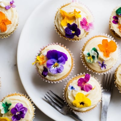 A close-up of Wild Flower Cupcakes topped with delicate violets and pansies, perfect for afternoon tea or garden party dessert.