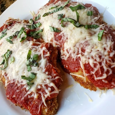 Close-up shot of the Amazing 15 Minute Keto Chicken Parmesan featuring bubbly cheese and rich tomato sauce over juicy chicken, perfect for a quick low-carb dinner.