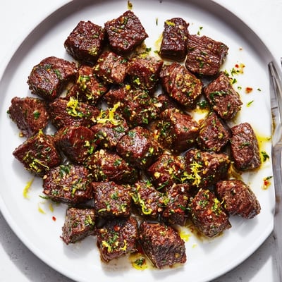 Plated Cowboy Butter Steak Bites recipe with charred edges, lemon zest, parsley garnish  